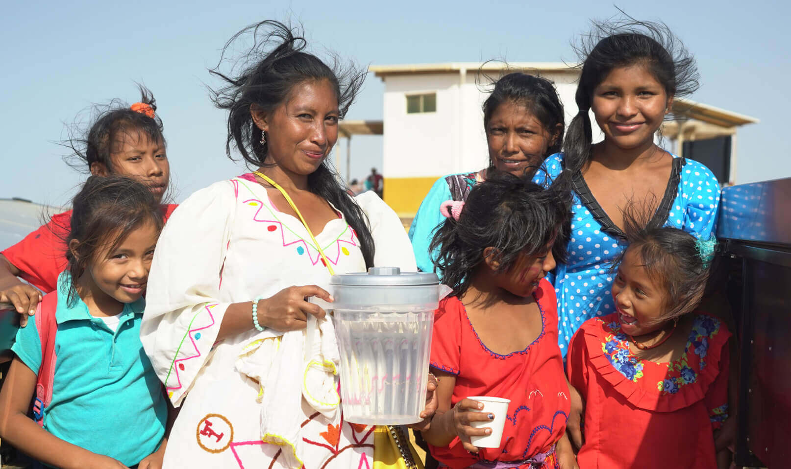 women and children in village sharing clean source water meta 3